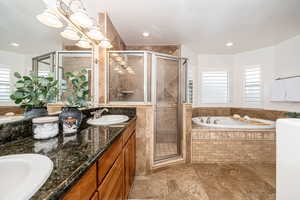 Bathroom with vanity, separate shower and tub, and a textured ceiling