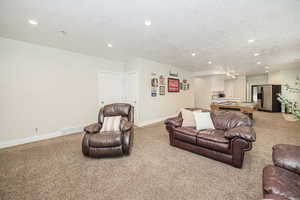 Living room with light carpet and a textured ceiling