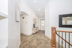 Hallway featuring a wealth of natural light and high vaulted ceiling