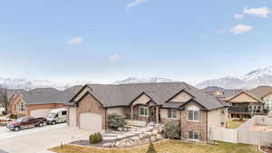 View of front of home with a garage, a mountain view, and a front lawn