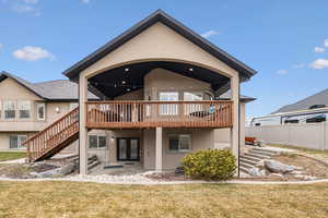 Rear view of property featuring a wooden deck, a yard, a patio area, and french doors