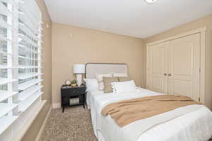 Bedroom featuring light carpet and a closet