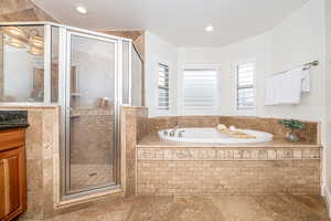 Bathroom featuring vanity and separate shower and tub