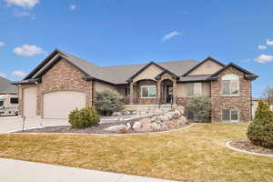 View of front of property featuring a garage and a front lawn