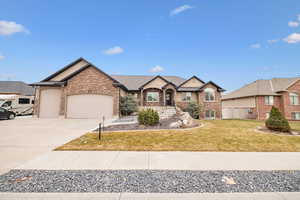 View of front of house with a garage and a front lawn