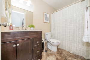 Bathroom with vanity, a textured ceiling, and toilet