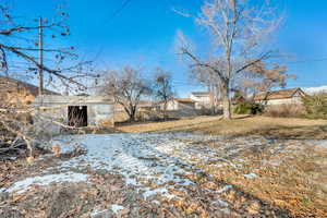 Yard covered in snow featuring an outbuilding