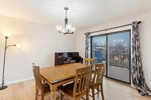 Dining space with a chandelier and light hardwood / wood-style flooring