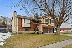 Bi-level home featuring a garage, a mountain view, and a front yard