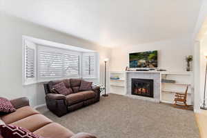 Carpeted living room featuring a brick fireplace