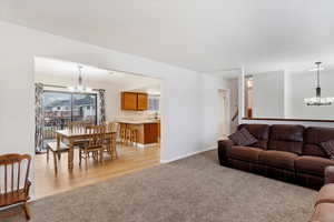 Living room with sink, light carpet, and a chandelier