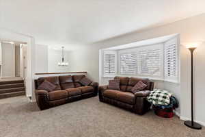 Living room with carpet flooring and a notable chandelier