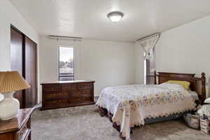 Bedroom with light carpet and a textured ceiling