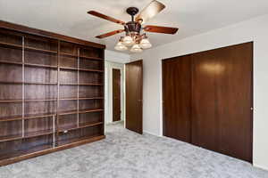 Unfurnished bedroom featuring ceiling fan and light carpet