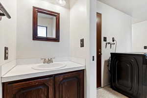 Bathroom with vanity and washer / clothes dryer