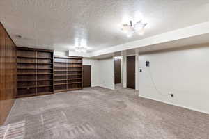 Basement featuring a textured ceiling and carpet