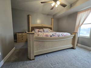 Bedroom with dark colored carpet and ceiling fan