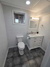 Bathroom with vanity, a paneled ceiling, and toilet