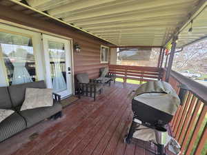 Wooden terrace featuring a grill