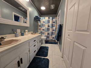 Bathroom with ornamental molding, toilet, and vanity