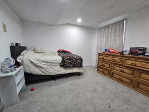 Carpeted bedroom featuring a drop ceiling