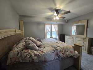 Carpeted bedroom featuring ceiling fan