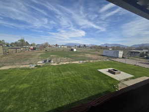 View of yard with fence, a fire pit, and a mountain view