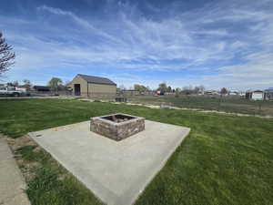 View of yard with fence and an outdoor fire pit