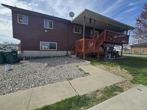 Back of house featuring a wooden deck and a lawn