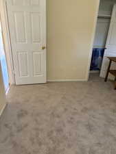 Unfurnished bedroom with carpet, a closet, and baseboards