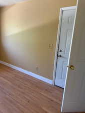 Spare room featuring baseboards and wood finished floors