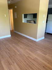 Unfurnished living room featuring light wood-style flooring and baseboards