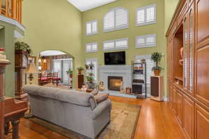 Living room with a high ceiling and light hardwood / wood-style flooring