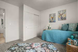 Bedroom featuring carpet flooring, a textured ceiling, and a closet