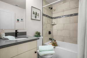 Bathroom featuring shower / bath combo, vanity, and a textured ceiling