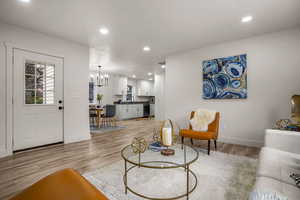 Living room featuring an inviting chandelier and light wood-type flooring