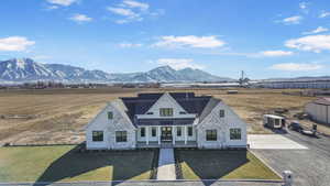 View of front facade with a porch, a mountain view, and a front lawn