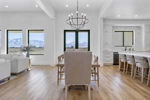 Dining space featuring an inviting chandelier, a mountain view, light hardwood / wood-style flooring, and sink