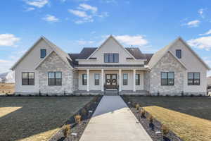 View of front of property featuring a front yard, french doors, and covered porch