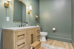 Bathroom featuring vanity, hardwood / wood-style flooring, and toilet