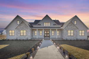 View of front of property featuring a lawn, french doors, and covered porch