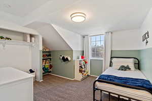 Carpeted bedroom featuring lofted ceiling