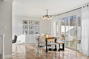 Dining space featuring an inviting chandelier, light tile patterned floors, and crown molding