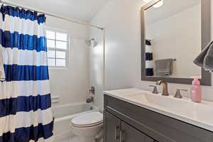 Full bathroom featuring vanity, toilet, and shower / tub combo