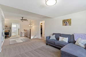 Living room featuring ceiling fan and carpet