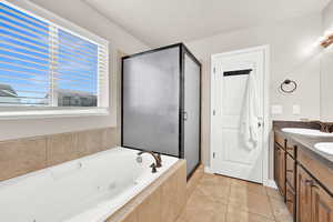 Bathroom featuring independent shower and bath, vanity, and tile patterned floors