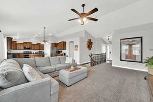 Living room featuring light carpet, sink, vaulted ceiling, and ceiling fan