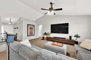 Living room with ceiling fan, lofted ceiling, and carpet floors