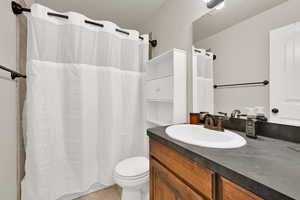 Bathroom with tile patterned flooring, vanity, and toilet