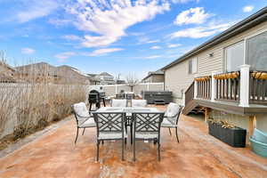 View of patio with area for grilling and a hot tub